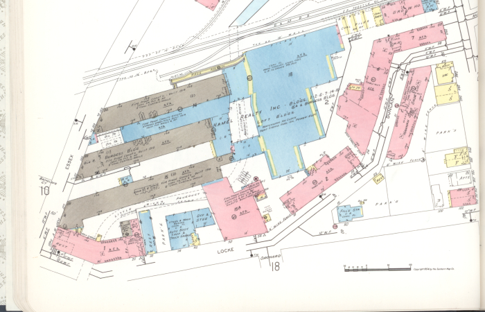 A multicolored map shows three long, parallel factory buildings at the lower left. The Little River comes from the top right and passes behind the three buildings, weaving through a range of other historic brick buildings.