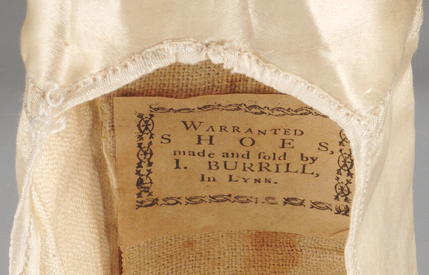 A label inside of a shoe reads, “Warranted shoes, made and sold by I. Burrill, In Lynn.”
