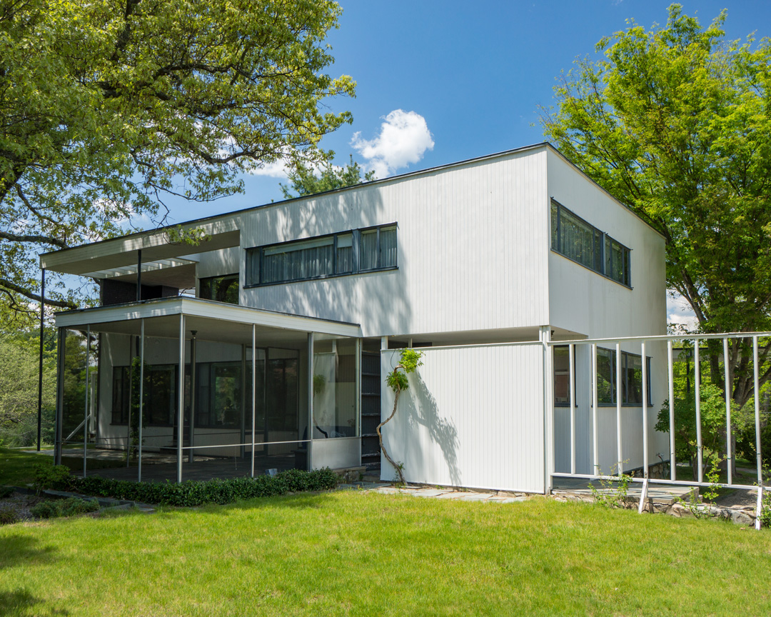 An exterior view of Gropius House, a white modernist home with squared-off walls and a flat roof.