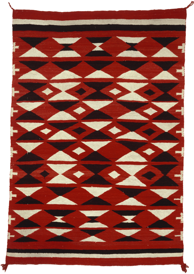 A woven red rug patterned with black and white diamonds and triangles and a black and white border.